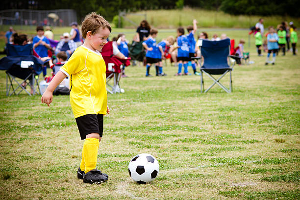 istock Young boy wearing yellow playing soccer 501441191