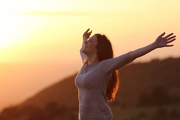 kobieta o zachodzie słońca oddech świeżego powietrza podnoszenie broni - yoga young adult cheerful happiness zdjęcia i obrazy z banku zdjęć