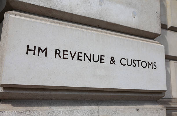 HM Revenue and Customs London, England - May 5th, 2014: Sign outside the offices of Her Majesty's Revenue and Customs along Whitehall in Central London. Formed by a merger of the Inland revenue and Customs and Excise the departments main responsibility is the collection of taxes. hm government stock pictures, royalty-free photos & images