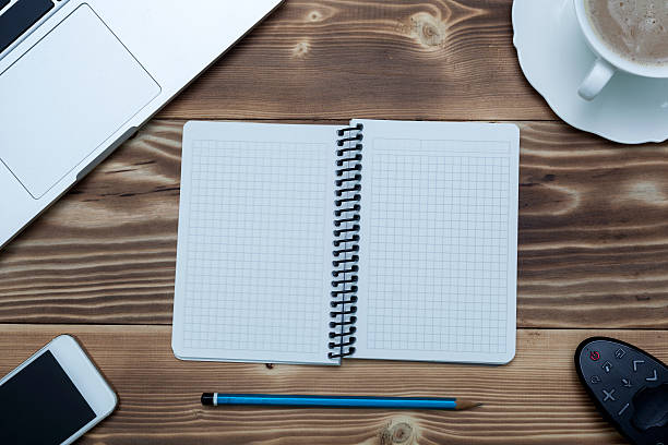 istock Notebook with laptop, mobile phone  and coffee on desk 501456126