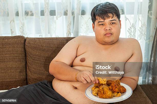 Asian A Man Eating Fried Chicken Stock Photo - Download Image Now - Fried Chicken, Eating, Fat - Nutrient