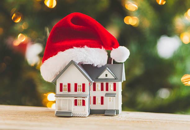 istock House with Santa hat under Christmas tree. Relocation concept. 501458148