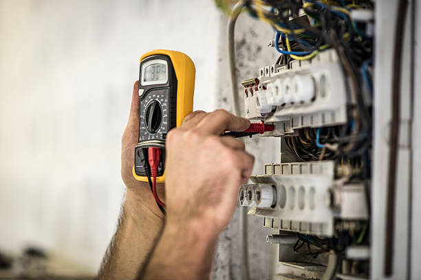 Testing voltage Detail shot of electrician testing voltage on a fuse box on construction site. multimeter stock pictures, royalty-free photos & images