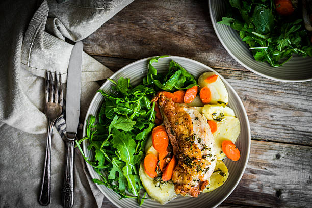 istock Chicken with potatoes and arugula salad on rustic background 501464608