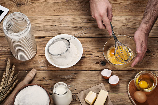 istock Male chef whipping eggs in the bakery on wooden table 501464980