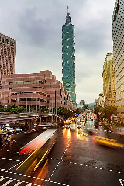 Street scene in the capital city of Taiwan at dusk with motion blurred taxis and traffic in the streets of Taipei. 101 Skyscraper in the background. Long exposure, Taipei, Taiwan. Made with Nikon D810 36MPixel. 