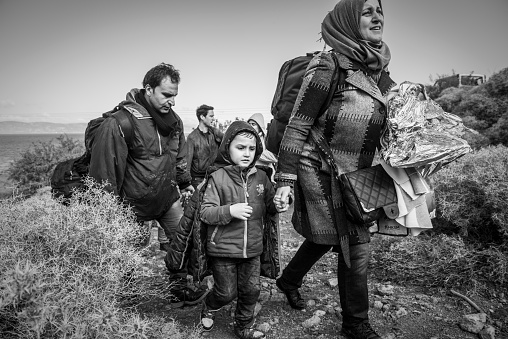 Lesbos, Greece - October 25, 2015: Having just landed in a small boat from Turkey, an Arab family walks up from the beach toward a road on the north coast of the Greek island of Lesbos. They are among more than 500,000 migrants and refugees who have crossed from Turkey to the Greek islands in 2015.
