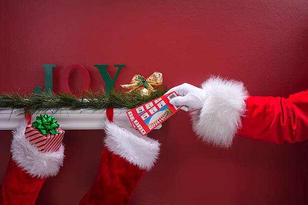 istock Santa's hand placing Baseball tickets into Christmas Stockings 501466720