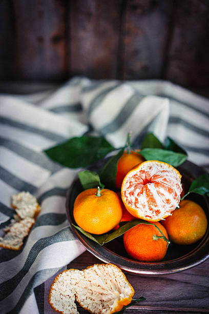 istock Tangerines with leaves on rustic wooden background 501467436
