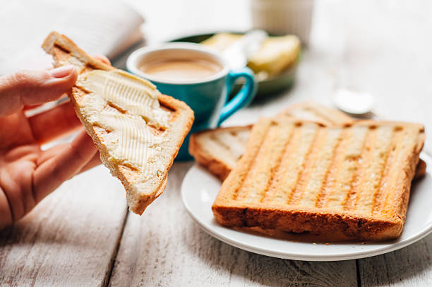istock Woman hand eating toast for breakfast 501478148
