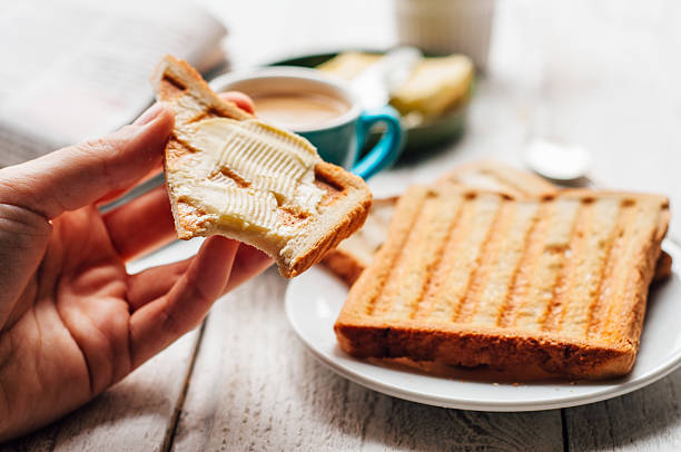 istock Woman hand eating toast for breakfast 501478192