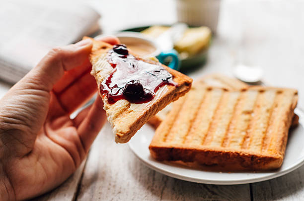 istock Woman hand eating toast for breakfast 501478216