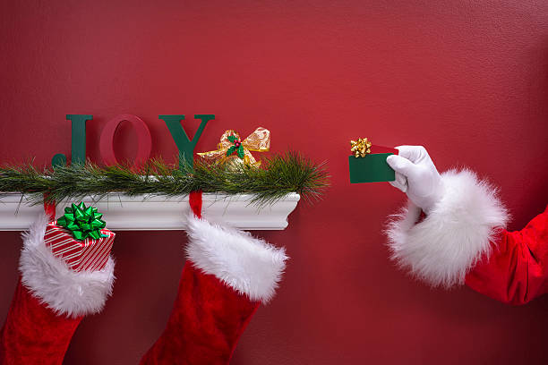 istock Santa's hand holding two gift cards into Christmas Stockings 501480256