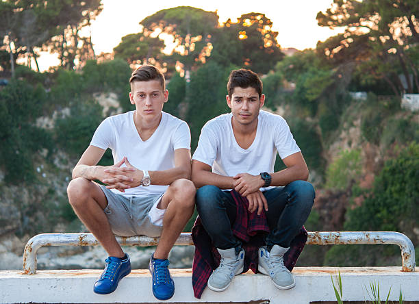 Two guys sitting on fence