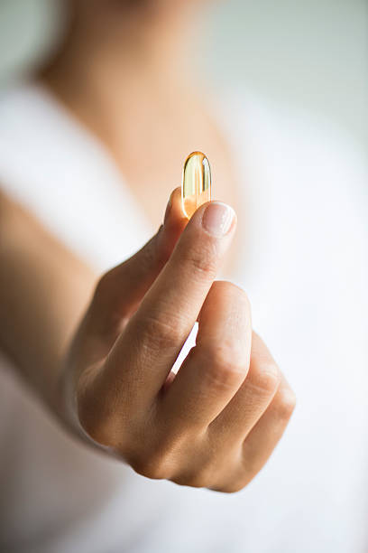 istock Woman Holding And Showing Omega 3 Capsule 501480554