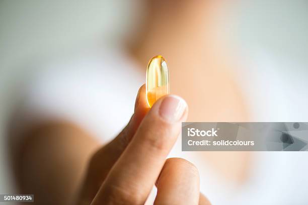 Woman Holding And Showing Omega 3 Capsule Stock Photo - Download Image Now - Capsule - Medicine, Nutritional Supplement, Women