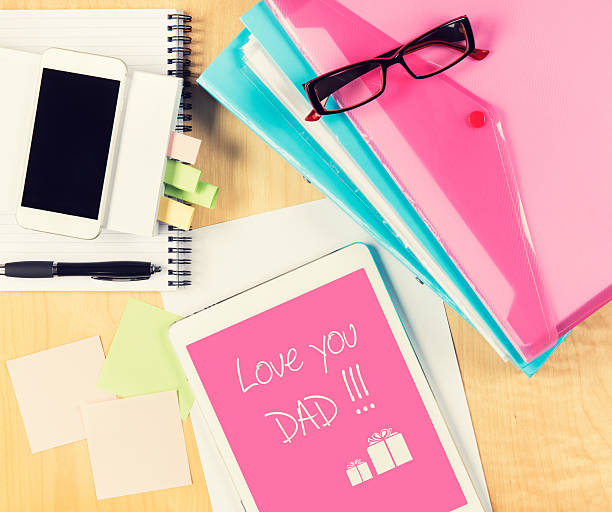 istock Messy office table with Fathers day card on digital tablet. 501481458