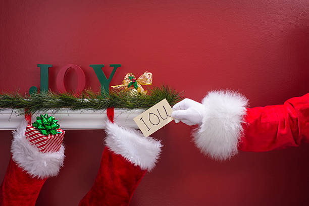 istock Santa's hand placing an IOU note into Christmas Stockings 501482704
