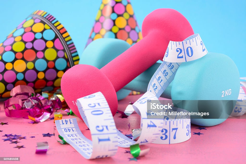 New Year Exercise Resolution. New Year Exercise Resolution with dumbbells and party decorations on white and blue background. 2015 Stock Photo