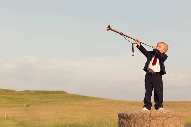 istock Young Boy Businessman Blows a Trumpet 501485202