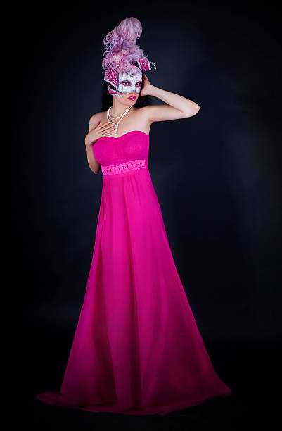 Sexy woman in pink dress and venetian mask Sexy woman in pink dress and venetian mask isolated on black dark pink dress stock pictures, royalty-free photos & images