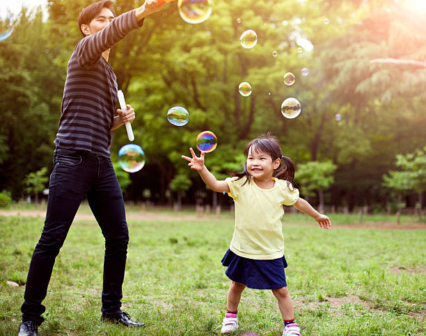 istock Father and daughter having fun in park with Soap Bubbles 501485932