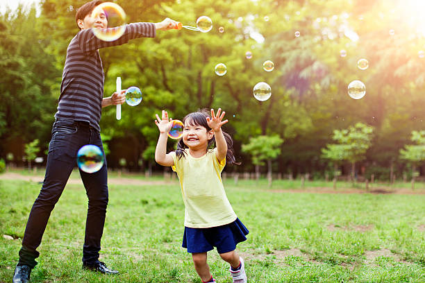 istock Father and daughter having fun in park with Soap Bubbles 501485972