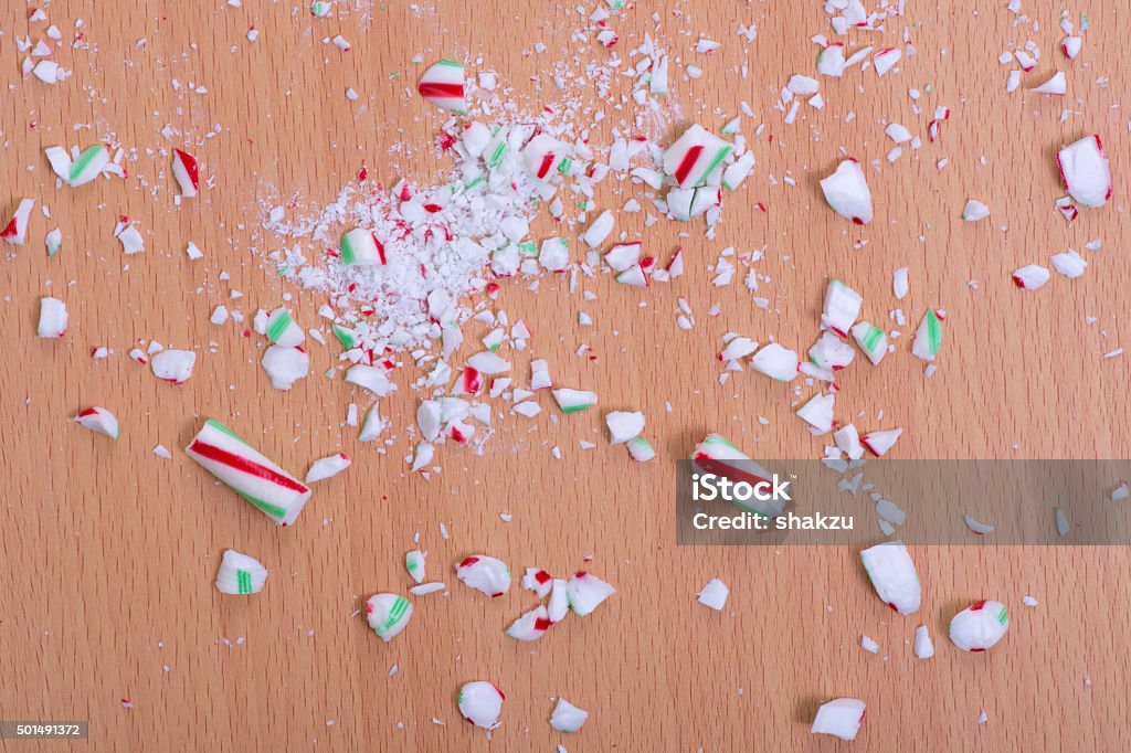 Crushed candy cane on floor Pieces of broken Christmas candy cane shattered on wood floor Candy Stock Photo