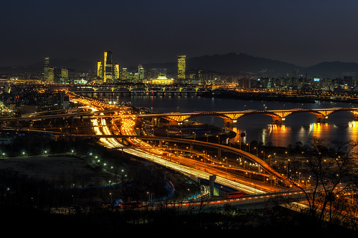 Rushhour traffic viewed from haneul park in mapo province of Seoul nearby the world cup stadium. The view of seongsan bridge and yeouido park with the national assembly in the distance.