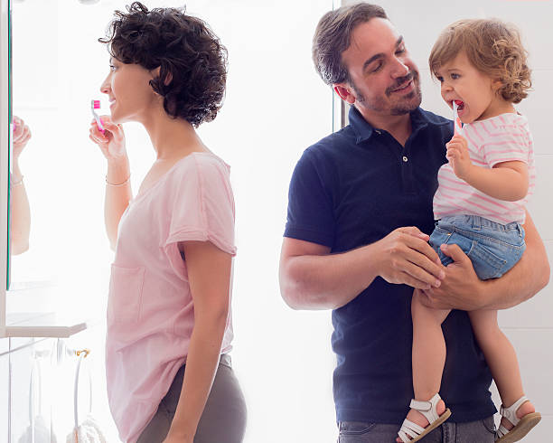 istock Family Brushing Teeth In Bathroom Mirror 501510291