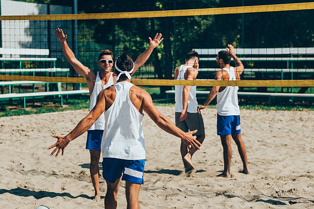 voleibol de praia da equipa para vencer um ponto importante - beach body ball volleyball imagens e fotografias de stock