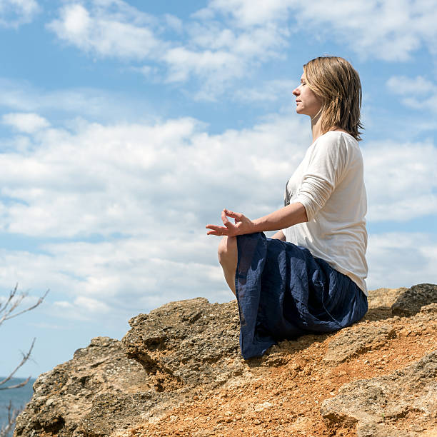 Woman meditating at the sea stock photo