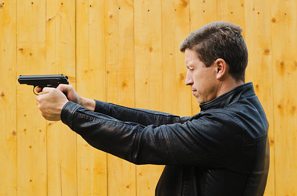 istock The man shoots from a pistol, having closed eyes 501512855