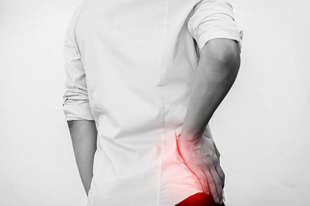 Young man in casual office shirt having hip pain stock photo