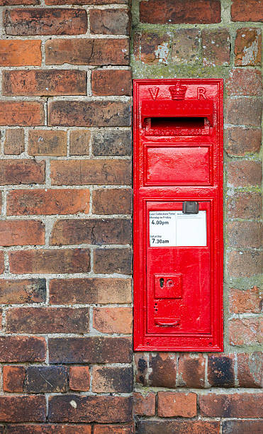 istock Red Victorian letter box encased in a village brick wall 501514299