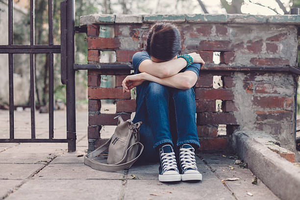 Depressed girl at the street Crying girl with head in hands sitting on the ground post traumatic stress disorder photos stock pictures, royalty-free photos & images
