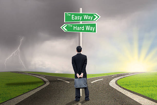 istock Businessman with sign of easy vs hard way 501516117