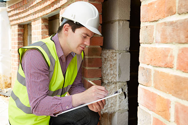 Architect Checking Insulation During House Construction Architect Checking Insulation During House Construction inspector stock pictures, royalty-free photos & images