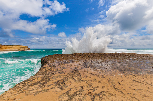 Big wave breaks on a rock with explosion like splashes, Great Ocean Road, Australia