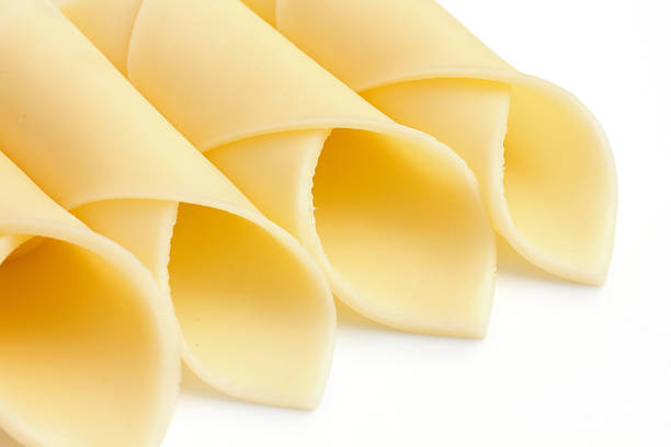 istock Wrapped yellow cheese slices arranged on a white surface. 501533611
