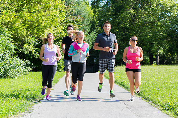 istock Group of runners jogging through park 501533691