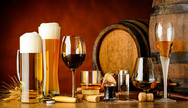 alcoholic drinks alcoholic drinks on wooden table in glasses, mugs and shots with barrel in background beer styles stock pictures, royalty-free photos & images