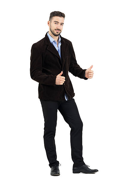 Man in corduroy jacket with o.k. gesture smiling at camera Young man in corduroy jacket with o.k. hand gesture smiling at camera. Full body length portrait isolated over white studio background corduroy jacket stock pictures, royalty-free photos & images