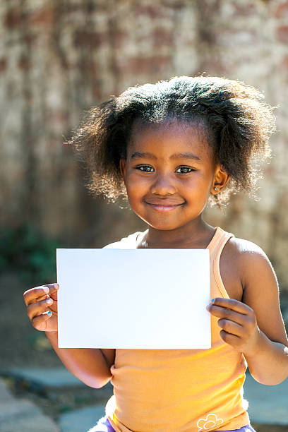istock Cute african girl holding white blank card. 501535233