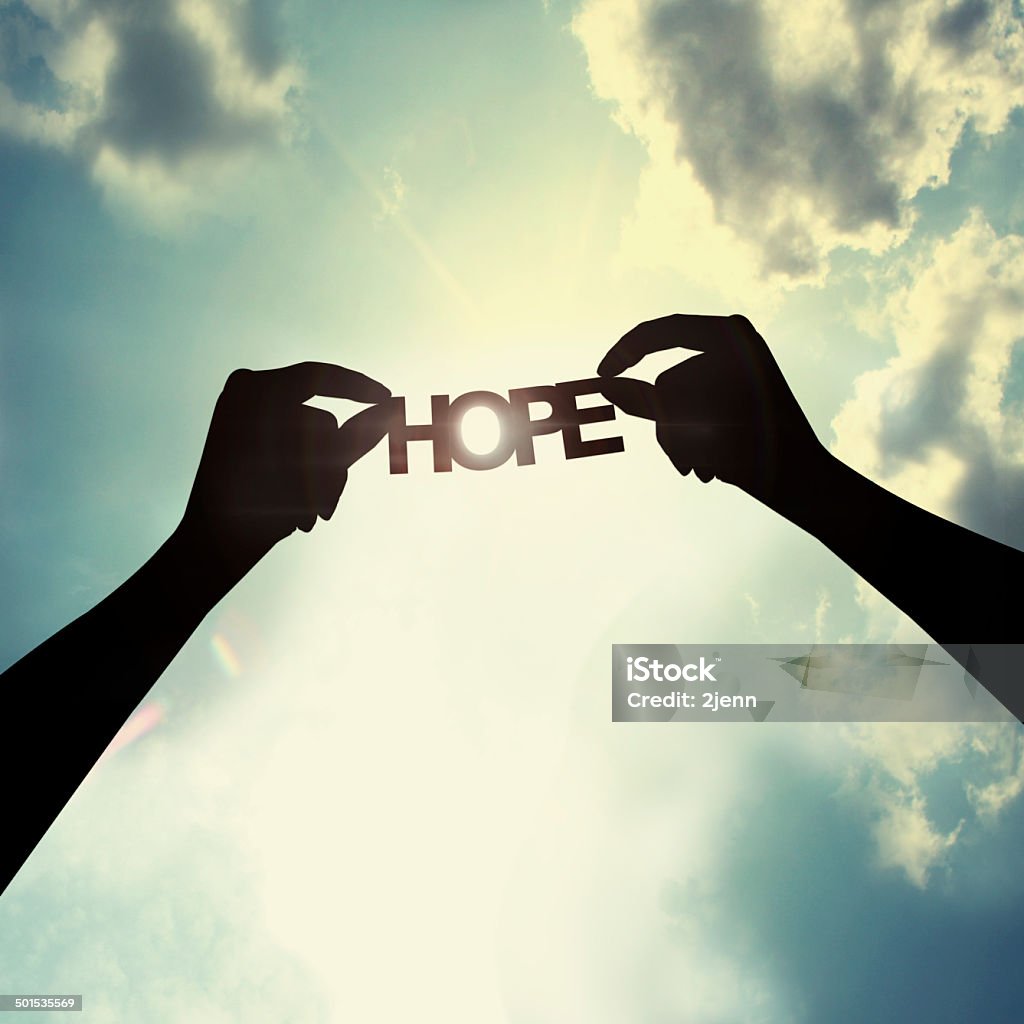 Holding paper cut of hope Show the paper cut word in the sky Hope - Concept Stock Photo