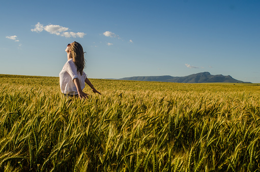 A woman walks through a wheat field on a spiritual adventure