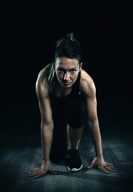 istock Athletic woman ready to run over dark background 501537356