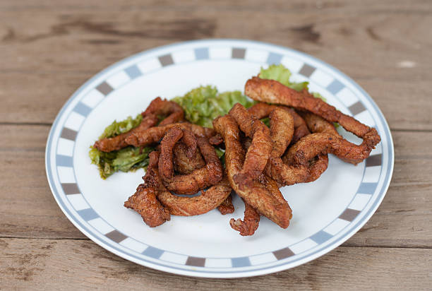 Fried pork with vegetable on wood background