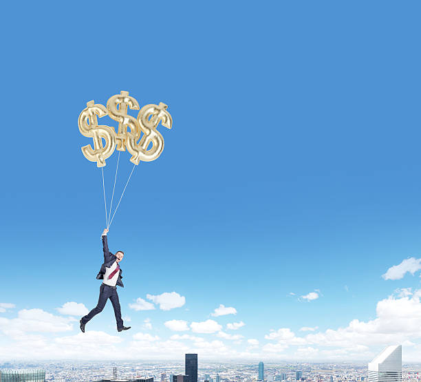 istock man flying with dollar balloons over city 501540096