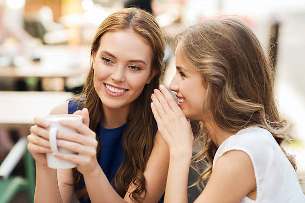 istock young women drinking coffee and talking at cafe 501541470